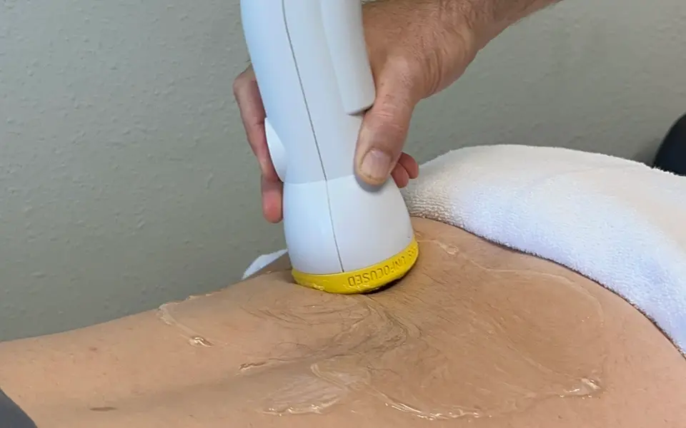 SoftWave applicator on a patient's lower back