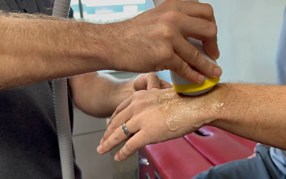 SoftWave applicator treating a patient's wrist and hand